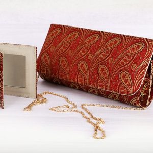 a red and gold brocade clutch purse with a matching mirror