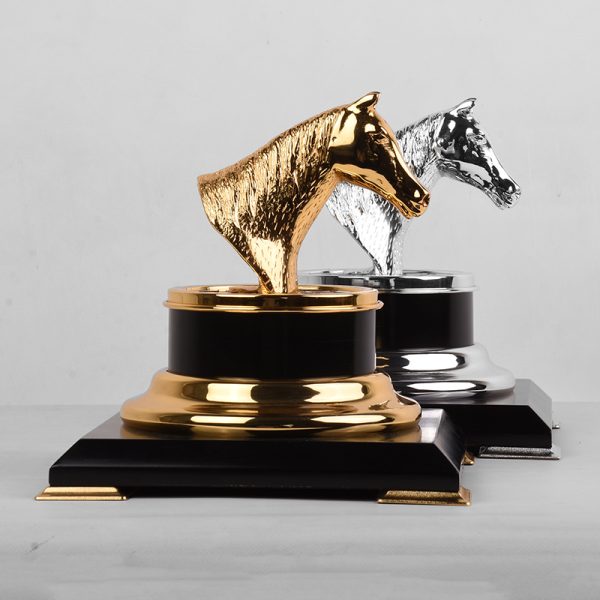 a silver or gold-plated brass horse head trophy on a black and gold base, symbolizing achievement and elegance