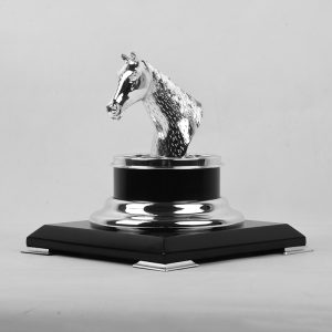 a silver-plated brass horse head trophy on a black and gold base, symbolizing achievement and elegance