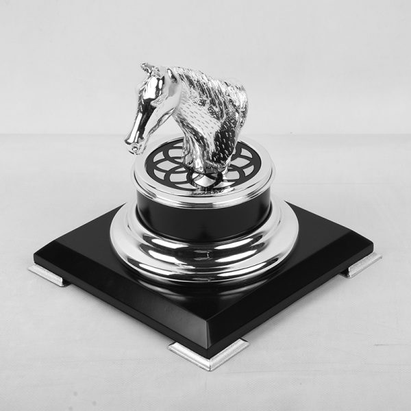 a silver-plated brass horse head trophy on a black and gold base, symbolizing achievement and elegance