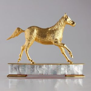 a gold-plated brass horse trophy on a mother-of-pearl and gold base, symbolizing achievement and elegance