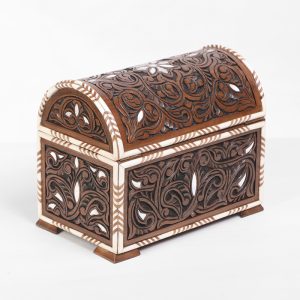 An intricately engraved walnut wood box, inlaid with mother-of-pearl and decorative bone.